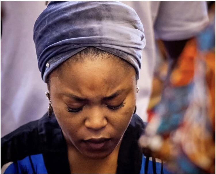 Woman with her head bowed in Church