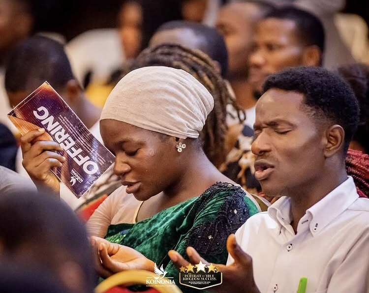 Members praying during offering time.
